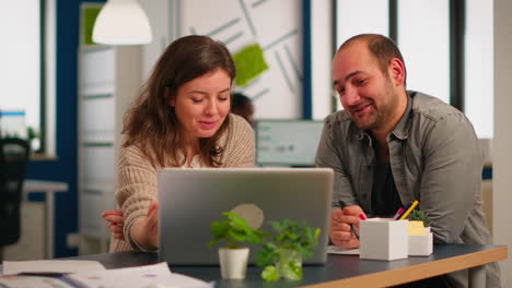 woman manager pointing on laptop showing new startup idea to coworkers