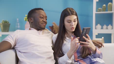 african young man bored and overwhelmed by his white girlfriend's shopping sickness.