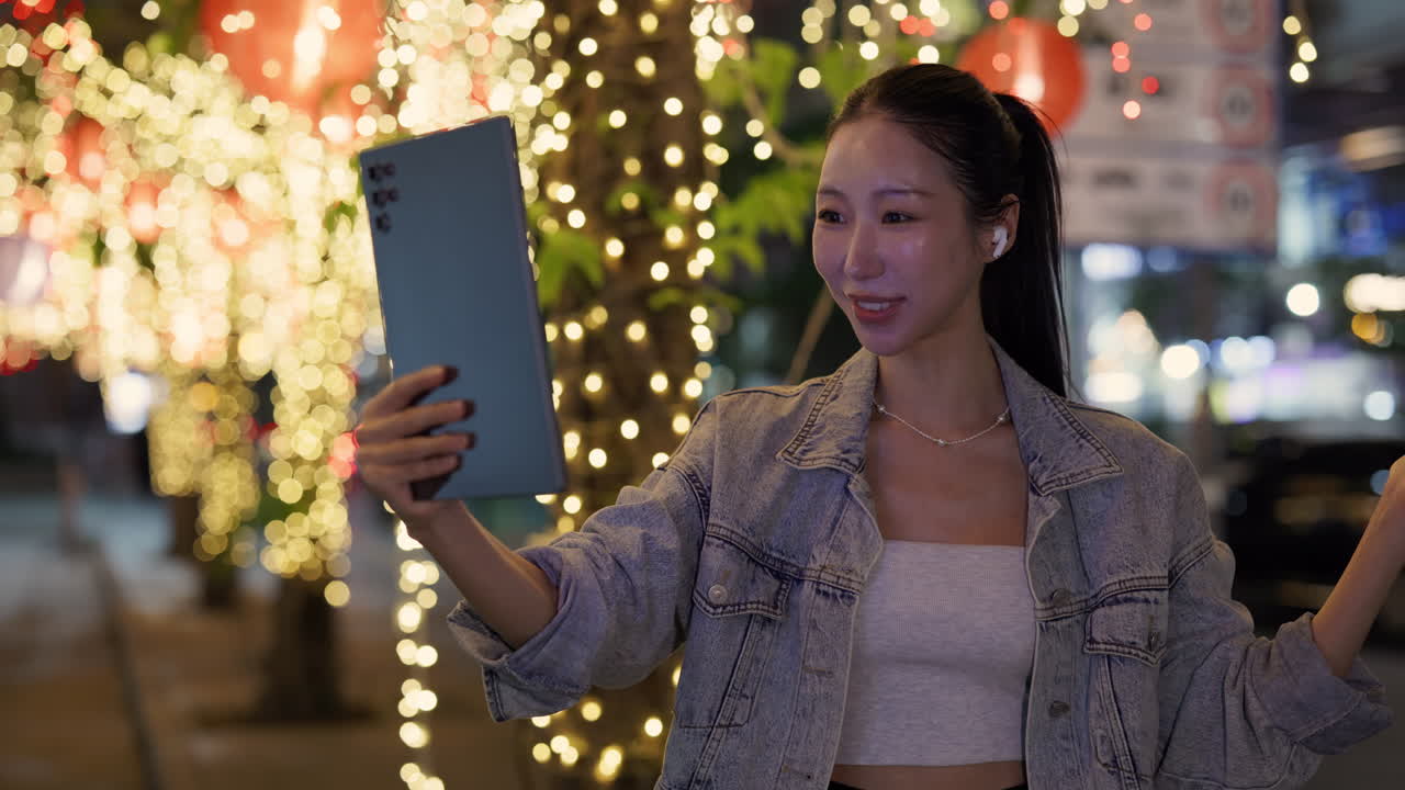 Woman taking a video with a tablet at night