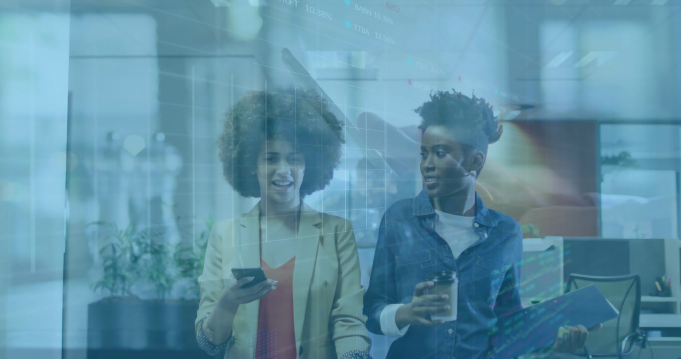 Two women colleagues entering office aisle and sharing smartphone data with animated code overlay