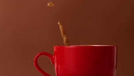 sugar cube falling into mug of tea