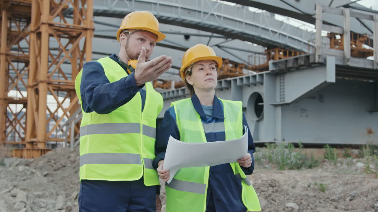 Construction Engineers Discussing Blueprint and Walking