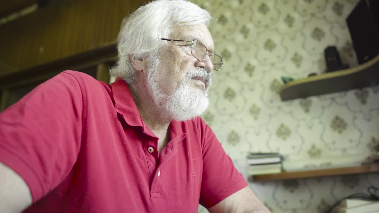 hombre maduro viendo una película en la computadora portátil en casa