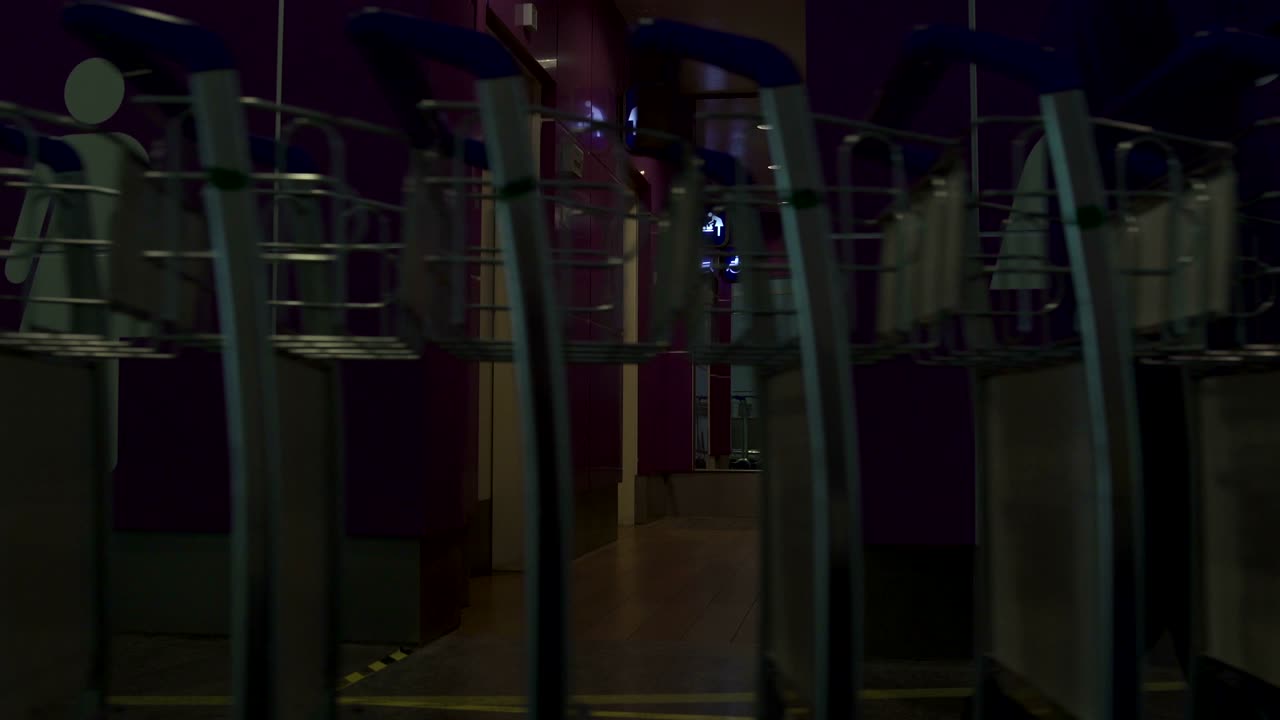 pasando carros para equipaje cerca de la entrada al baño en el aeropuerto