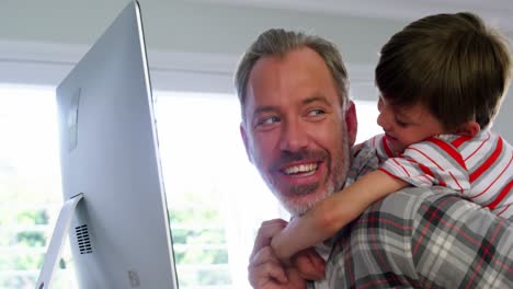 father and son using desktop pc