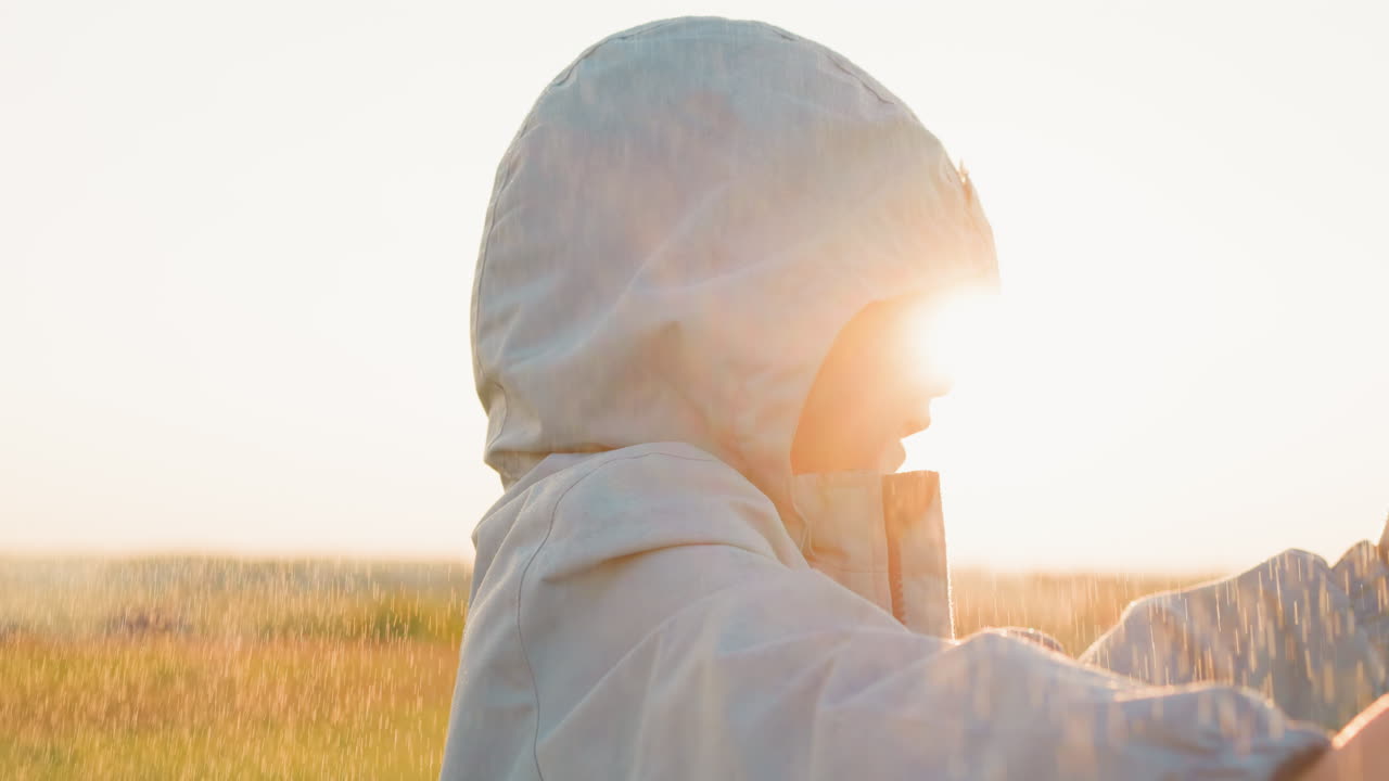 мальчик движется под дождем в солнечную погоду штормовая погода приносит волнующую атмосферу зажигает ребенка