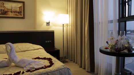 romantic hotel room with rose petals and swan towels