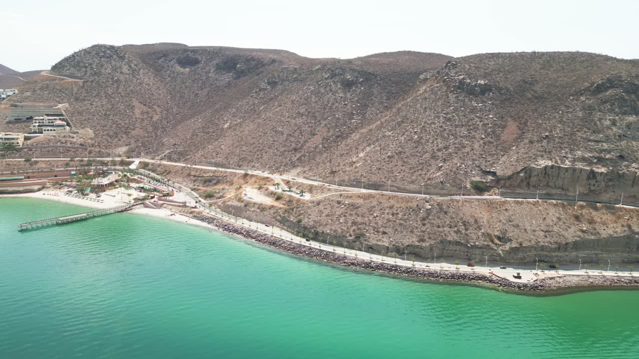 Drone footage of Playa Coromuel, La Paz, showcasing the calm turquoise water and rocky coastline