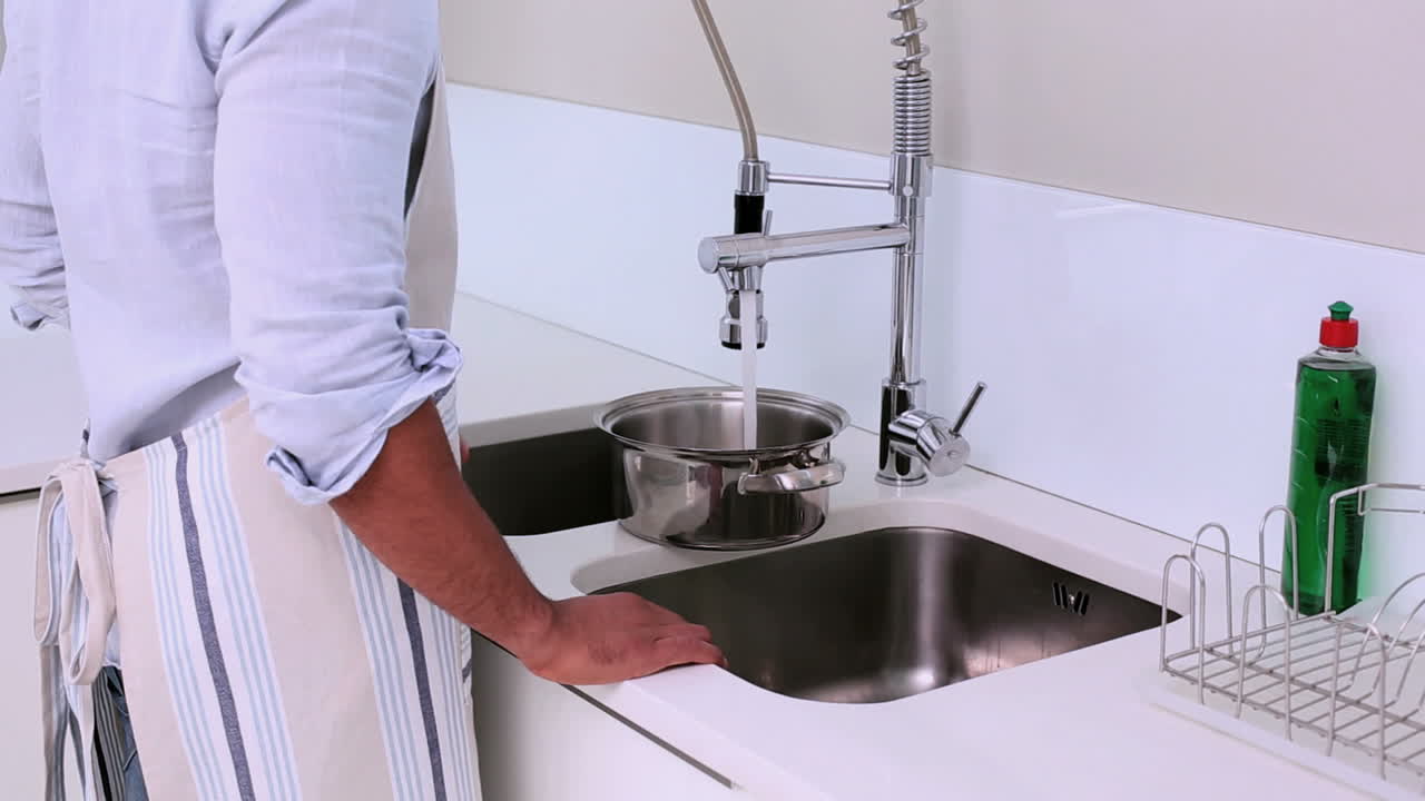Uomo che riempie una pentola d'acqua