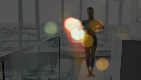 animación de coloridos puntos de luz contra la mujer asiática en forma practicando yoga en casa.