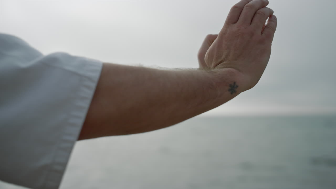 알 수 없는 스포츠맨의 손이 카라테 자세를 연습하고 있습니다. 강한 남자 훈련 힘