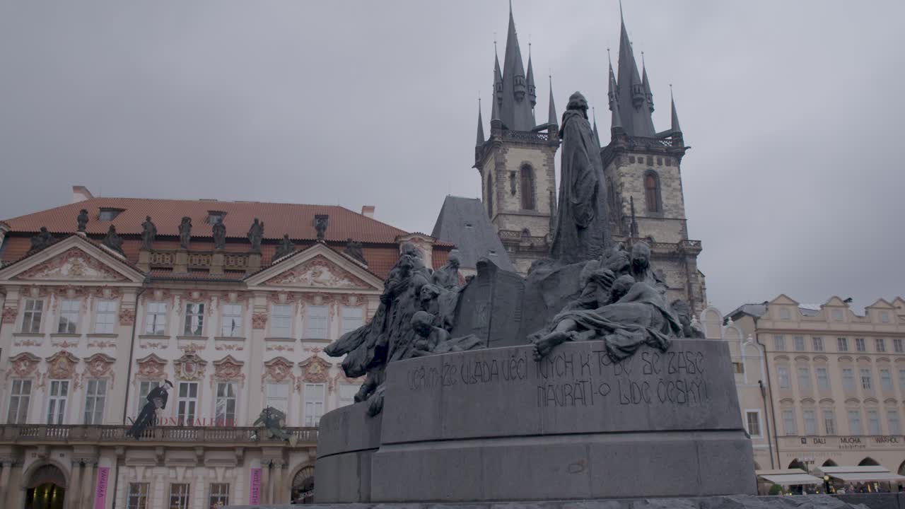 Jan Hus Memorial in Prague's Old Town Square with the Church of Our Lady before T&yacute;n in the background