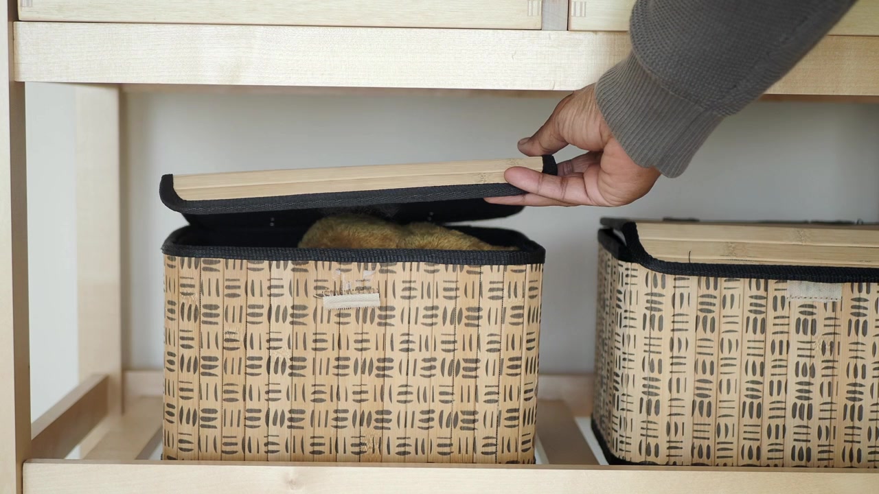 Persona che rimuove un cesto portaoggetti da uno scaffale di legno