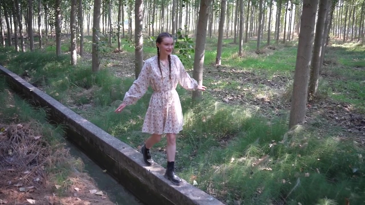 Una ragazza gioiosa che fa una piacevole passeggiata in un ambiente forestale sereno e pacifico.