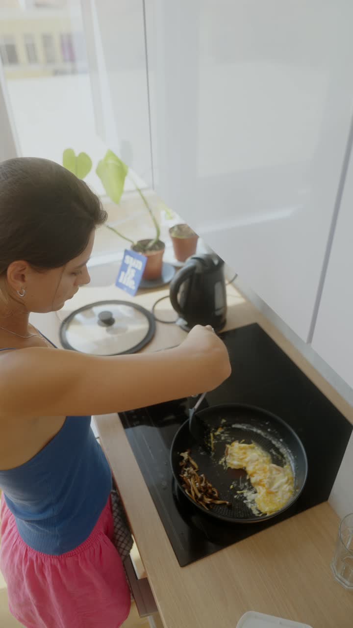 Una mujer cocinando el desayuno.