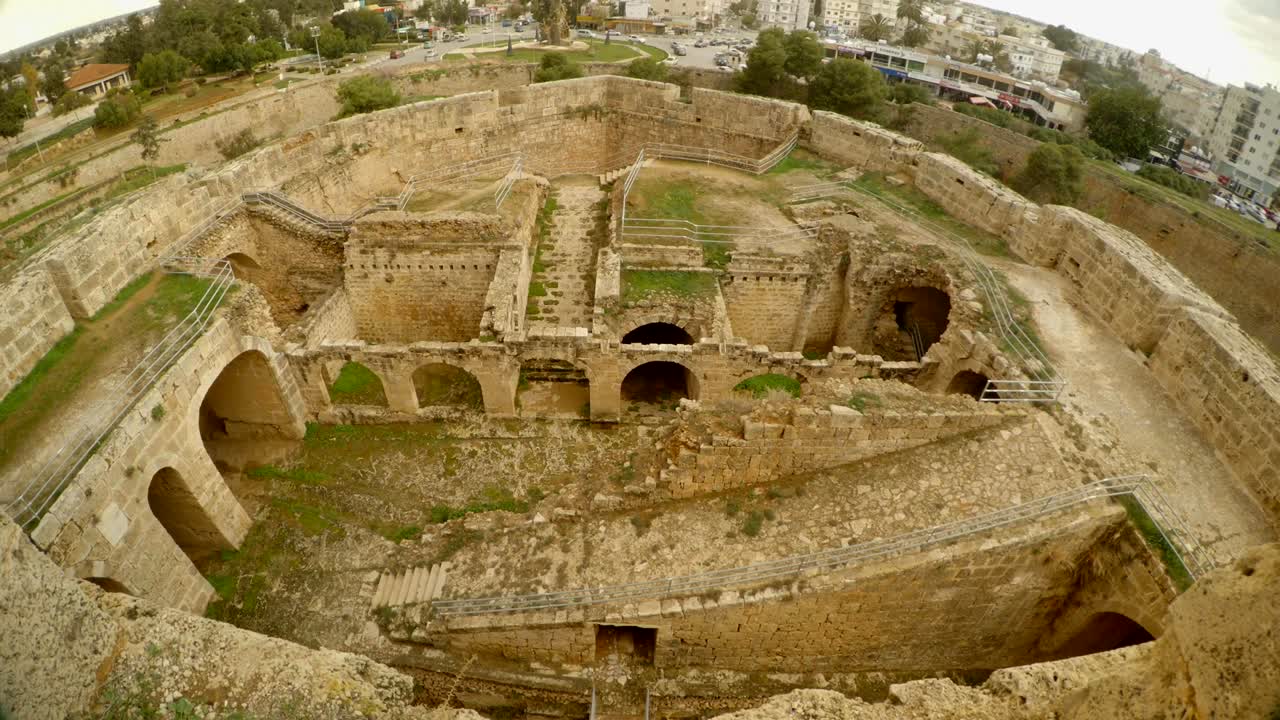ruinas de una fortaleza medieval y una ciudad moderna en la distancia