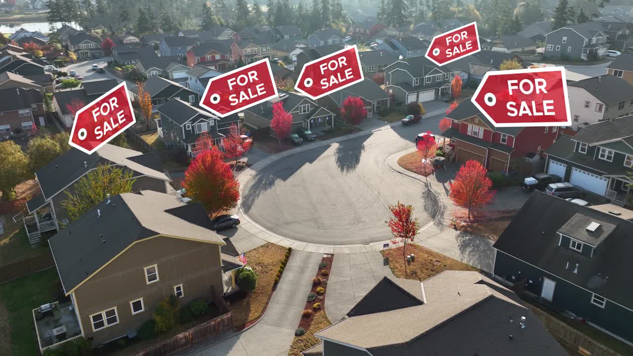 Drone shot of a suburban neighborhood with &amp;quot;FOR SALE&amp;quot; signs appearing over the houses