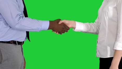 hands of businessman and businesswoman handshaking on a green screen, chroma key