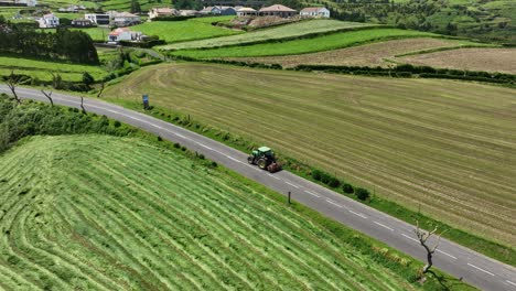 Luftaufnahme-Eines-Traktors-über-Der-Straße-Zwischen-Feldern-In-Sao-Miguel,-Azoren,-Portugal