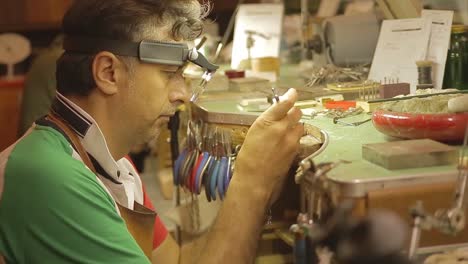 italian goldsmith at work building an engagement or a wedding ring