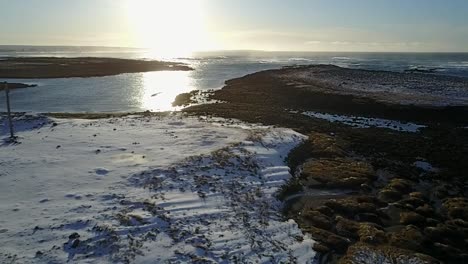 aerial shot pulling away from keflavik coast in winter at sunset