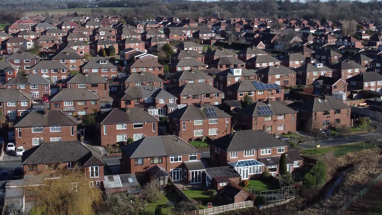 Luftaufnahme mit linkem Kameraschwenk von Dächern Londoner Vorstadthäuser und Immobilien.