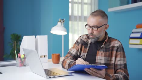 Businessman-working-on-laptop,-taking-notes.