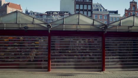 closed stalls of famous floating flower market at singel canal, bloemenmarkt, amsterdam, march 2021