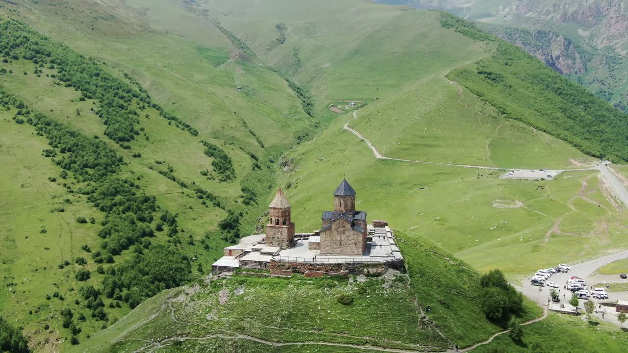 iglesia de la trinidad gergeti en majestuoso paisaje montañoso, vista de órbita aérea cinematográfica