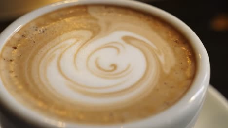 a beautifully crafted cup of coffee with intricate latte art showcasing whirls and swirls, perfect for coffee lovers and enthusiasts alike