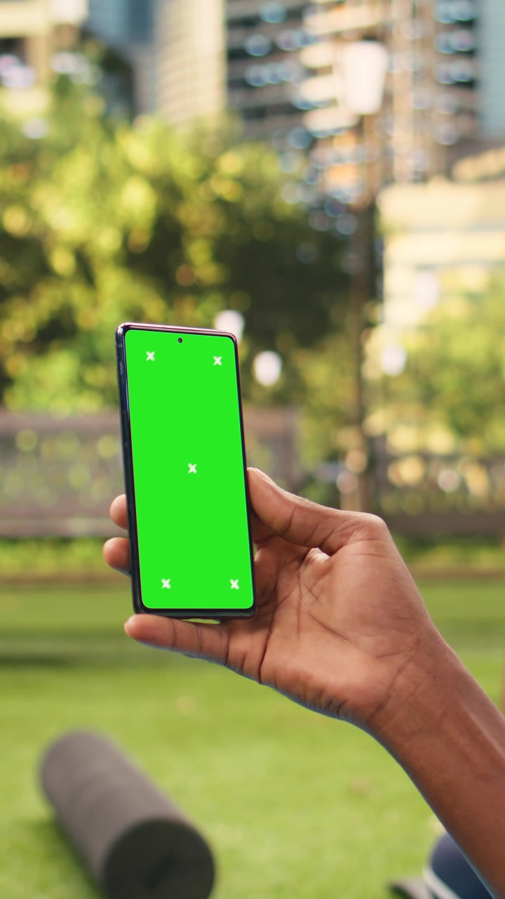 Video verticale: mockup chroma key verticale su un telefono cellulare tenuto in mano da un uomo