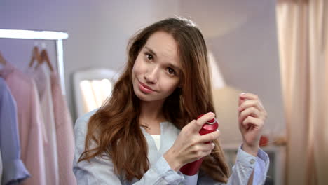 mujer alegre aplicando spray en el cabello