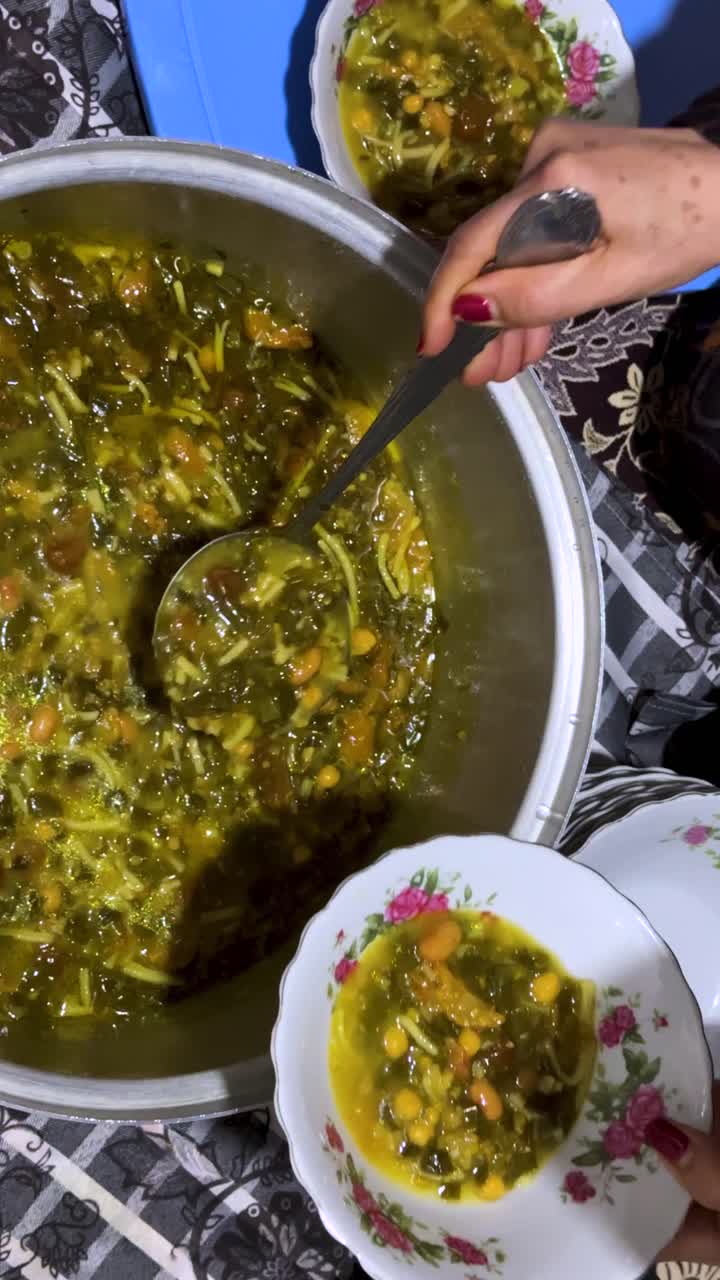 Nevruz'da Kürdistan'da sıcacık bir evde sunulan geleneksel İran Fars yemeği yahni, lezzetli otlu erişte çorbası (aş kasesi); kuru nane, sarımsak, soğan, fasulye, ıspanak gibi malzemelerle hazırlanan, sıcak, aileye özgü, kırsal, huzurlu ve otantik lezzetler.