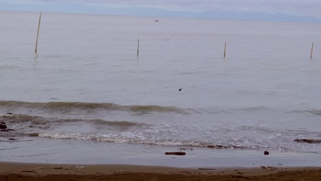 It's-early-in-the-morning-time-with-the-ocean-waves-crashing-to-the-shore-and-a-blury-mountain-in-the-background