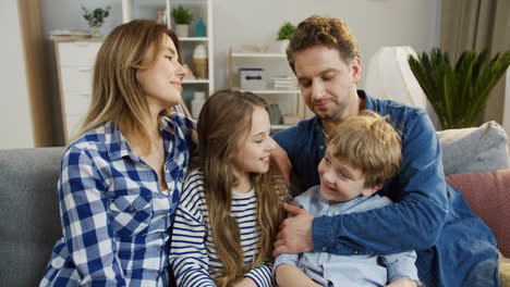 happy smiled family sitting on the sofa in the living room and smiling to the camera