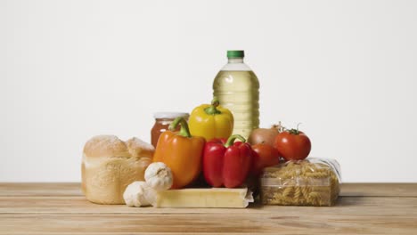 studio shot of basic food items on wooden surface and white background