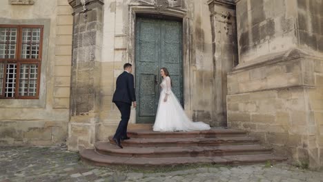 lovely newlyweds caucasian bride and groom with bouquet near castle, wedding couple first meeting