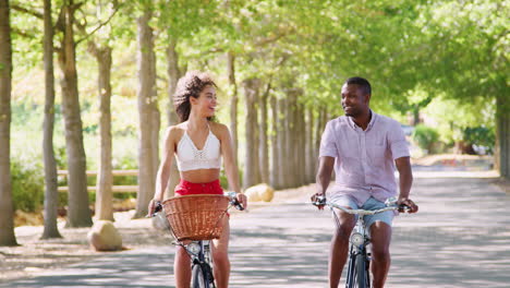 young couple riding bicycles looking at each other