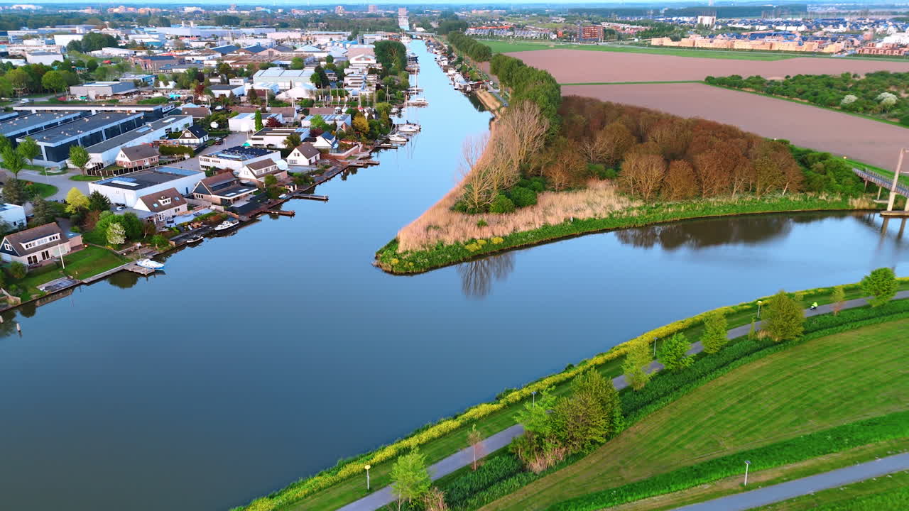 Beautiful picturesque village with canals instead of roads. Drone flight over the waterscape, fields and woods of Vinkeveen, the Netherlands.