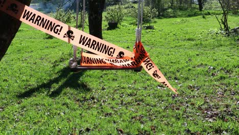 warning sign on ribbon on swing