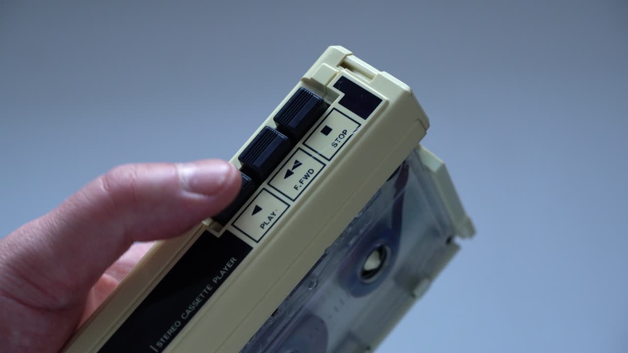 Finger switches on play of retro cassette tape on analog player