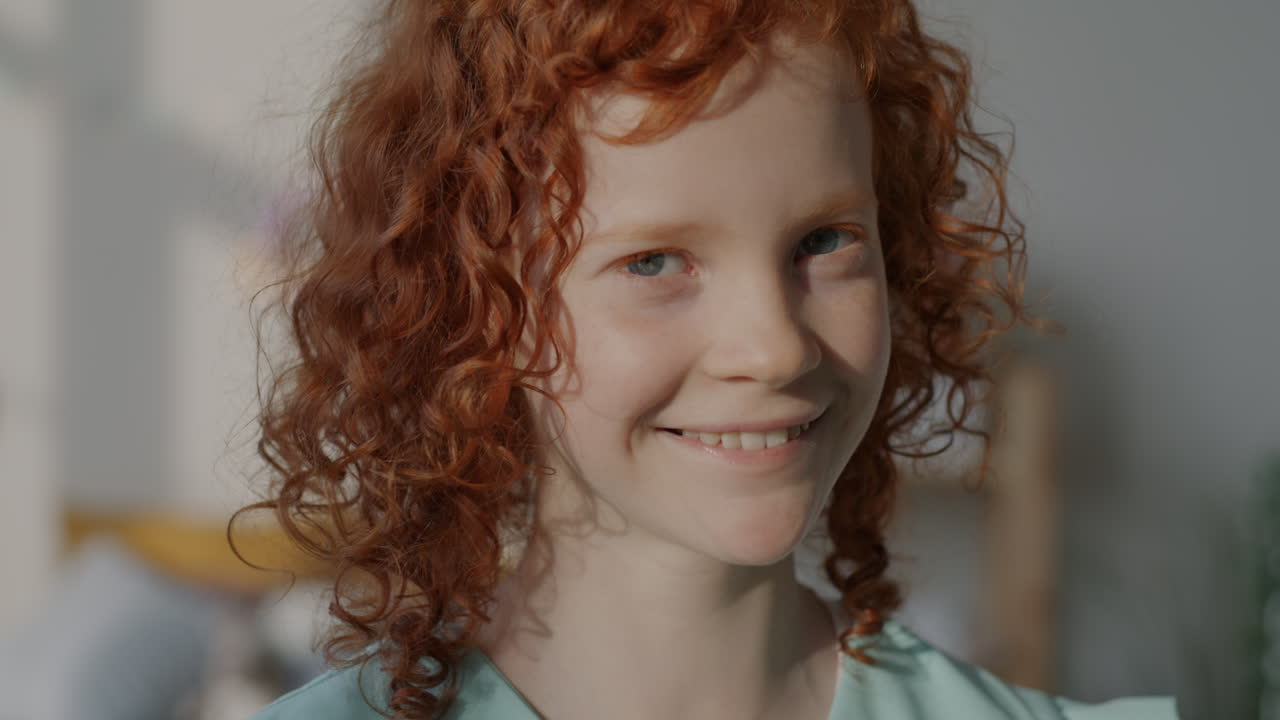 Portrait of a Smiling Girl with Curly Red Hair