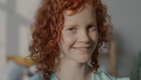 portrait of a smiling girl with curly red hair