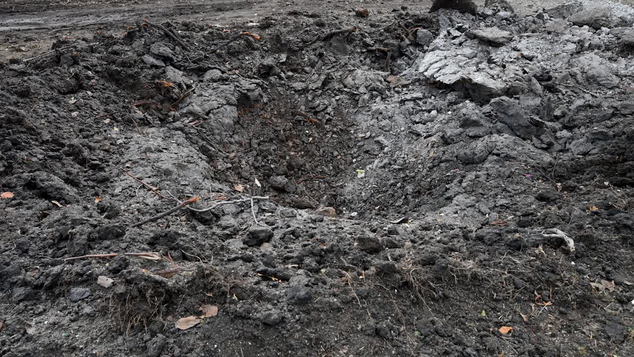 Tilt-up view of a scene of destruction on the outskirts of Kramatorsk in Ukraine's Donbas region. A missile crater and ruined homes are the result of a reported Russian attack on the area