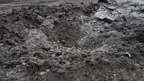tilt-up view of a scene of destruction on the outskirts of kramatorsk in ukraine's donbas region. a missile crater and ruined homes are the result of a reported russian attack on the area