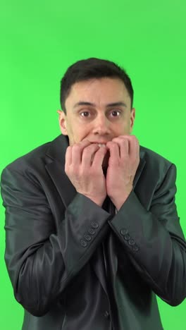 man reacts with shock and anxiety on green screen
