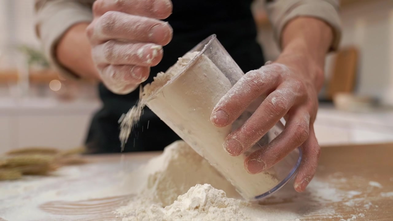 Close-up of Hands Working with Flour on a Wooden Surface