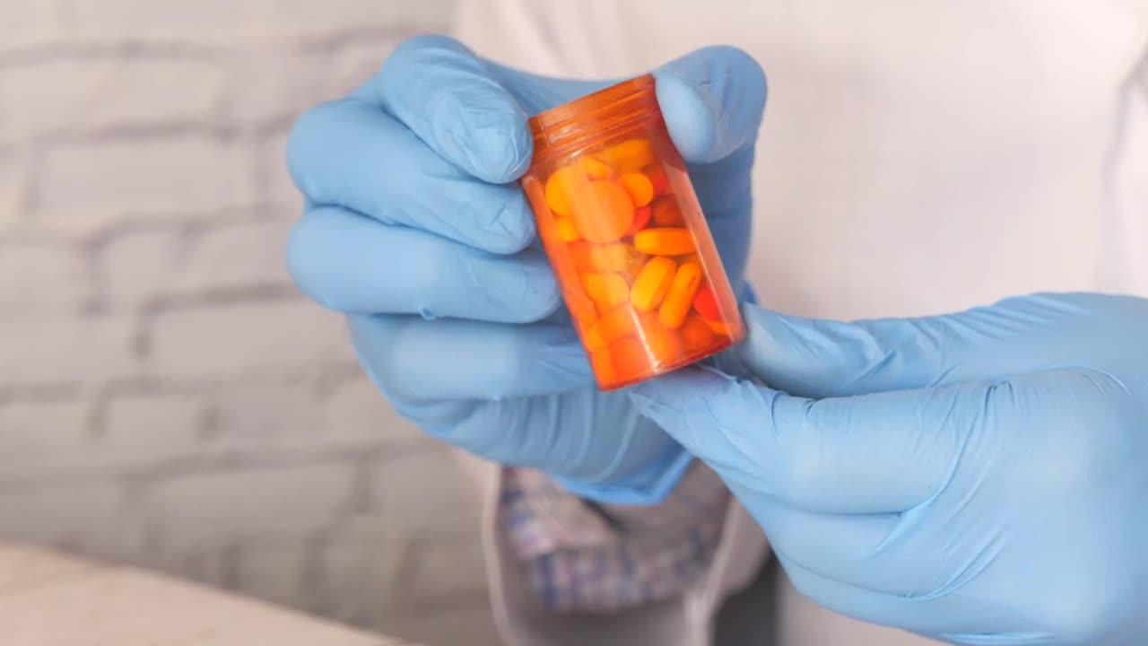 médico sosteniendo un recipiente de pastillas
