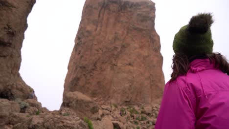 grupo de senderismo ascendiendo al roque nublo duroing una mañana brumosa en la isla de gran canaria, españa