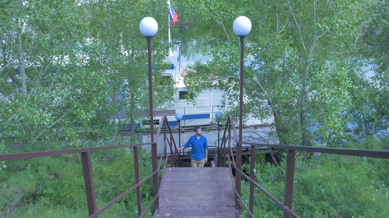 Man Walking Down Stairs at a River Dock